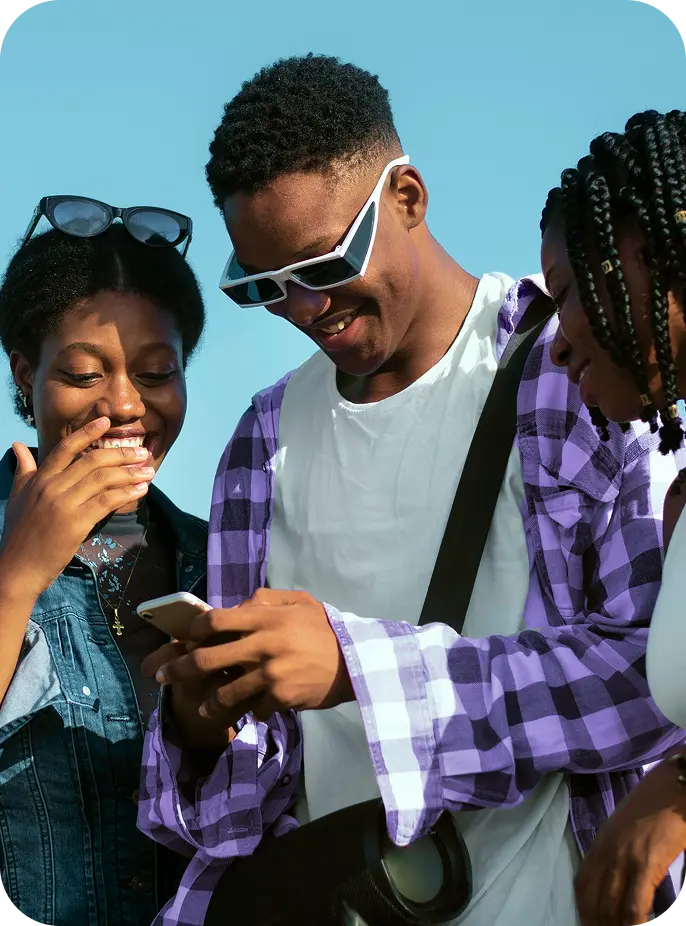 Three friends smiling at a phone as they send money with Pouchers